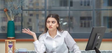 Thoughtful young lady point her hand aside and feels uncomfortable. High quality photo